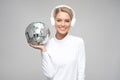 young woman in headphones holding a disco ball Royalty Free Stock Photo