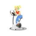 Young woman in headphones training on an exercise bike, girl working out in the fitness club or gym, active healthy Royalty Free Stock Photo