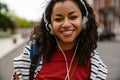 Young woman in headphones walking outdoors