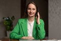 Young woman in headset speaks to camera sitting at table Royalty Free Stock Photo