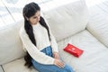 Young woman with health problem about her physical condition sits on the couch next to her home first aid kit Royalty Free Stock Photo