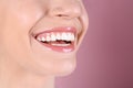 Young woman with healthy teeth and beautiful smile on color background, closeup. Royalty Free Stock Photo