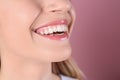 Young woman with healthy teeth and beautiful smile on color background, closeup. Royalty Free Stock Photo