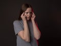 Young woman with heavy sharp headache, holding her temples with pain and hurt