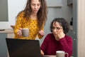 Young woman helps senior on laptop computer