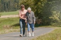 Young woman helps senior woman walking with stick Royalty Free Stock Photo