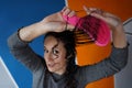 Young woman with her arms outstretched taking the pink brush holding her long hair Royalty Free Stock Photo