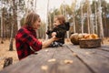 Young woman and her baby son in autumn park, boy playing with helloween pumpkin and eating pumpkin bun. Royalty Free Stock Photo