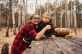 Young woman and her baby son in autumn park, boy playing with helloween pumpkin and eating pumpkin bun. Royalty Free Stock Photo