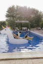 young woman and her border collie dog standing on an inflatable toy unicorn at the swimming pool. Summertime, fun and lifestyle Royalty Free Stock Photo