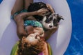 young woman and her border collie dog standing on an inflatable toy unicorn at the swimming pool. Summertime, fun and lifestyle Royalty Free Stock Photo