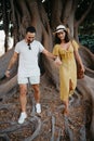 A young woman and her boyfriend walk under an old Valencian Ficus Macrophylla Royalty Free Stock Photo