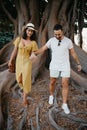 A young woman and her boyfriend walk under an old Valencian Ficus Macrophylla Royalty Free Stock Photo