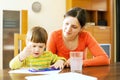 Young woman and her child painting with watercolor