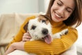 Young woman with cute Jack Russell Terrier at home, closeup. Lovely pet