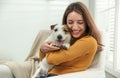 Young woman with cute Jack Russell Terrier at home. Lovely pet