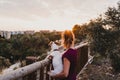 young woman and her cute small jack russell terrier dog watching sunset outdoors in a park. Golden hour. Love for animals concept Royalty Free Stock Photo