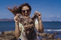 Young woman and her cute spanish water dog outdoors enjoying together on a sunny and windy day. Summertime, love for animals and