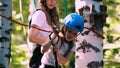 Young woman and her daughter crossing the rope on an attraction in the park Royalty Free Stock Photo