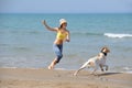 Young woman with her dog on the beach Royalty Free Stock Photo