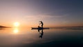 Young woman and her dog are doing paddlesurfing