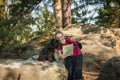 Young woman and her dog enjoy mountain hikes in summer