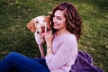 young woman with her dog at the park. she is hugging the dog. autumn season