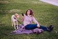young woman with her dog at the park. woman using mobile phone. autumn season Royalty Free Stock Photo