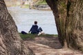 Young woman and her dog relax near the river Royalty Free Stock Photo