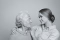 Young woman and her grandmother on light background. Black and white photography Royalty Free Stock Photo