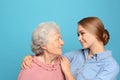 Young woman and her grandmother on blue background Royalty Free Stock Photo