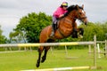 Young woman show jumping on her horse.