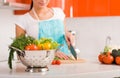 Young woman in her kitchen cutting ingredients