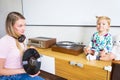 Young woman with her little daughter listens to music from vinyl records on a turntable at home.