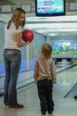 Young woman and her little son playing bowling. Active lifestyle of modern russian family.