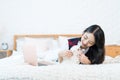 Young woman and her Maltese dog. Girl and puppy dog on the bed in bedroom Royalty Free Stock Photo