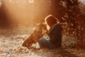 Woman and her mixed breed dog posing outdoors in sunlight together