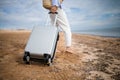 Business woman with suitcase luggage on sandy beach view on sunny day. Asian female on ocean shore having fun watching waves Royalty Free Stock Photo