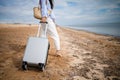 Young woman with her suitcase luggage on beautiful sandy beach view on sunny day. Asian female on ocean shore having fun watching Royalty Free Stock Photo