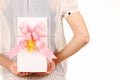 Young woman hide behind back the white gift box