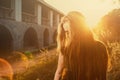 Young woman hide her face with long blond hair backlit by sun selective focus toned image, sun flares Royalty Free Stock Photo