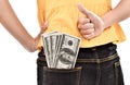 Young woman hide lots of dollars and showing thumb up Royalty Free Stock Photo