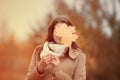Young woman hides face with autumn yellow maple leave. Royalty Free Stock Photo