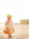 Young woman hiding behind colorful windmill toy Royalty Free Stock Photo