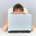 Young woman hiding behind a laptop Royalty Free Stock Photo