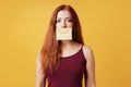 Young woman hiding sadness or depression behind fake smile drawn on paper