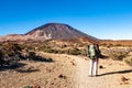 Young woman hiker with backpack looking at Pico del Teide mountain in El Teide National park. Tenerife, Canary Islands, Spain Royalty Free Stock Photo