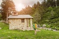 Woman hiker camping near the beautiful shelter stone hut building in Pyrenees mountains. Hiking and adventure concept Royalty Free Stock Photo