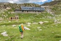 woman hiker camping near the beautiful shelter stone hut building in Pyrenees mountains. Hiking and adventure concept Royalty Free Stock Photo