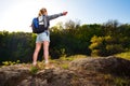 Young woman hiker enjoy the view in forest on the path during summer. Travel, hiking, backpacking, tourism and people concept